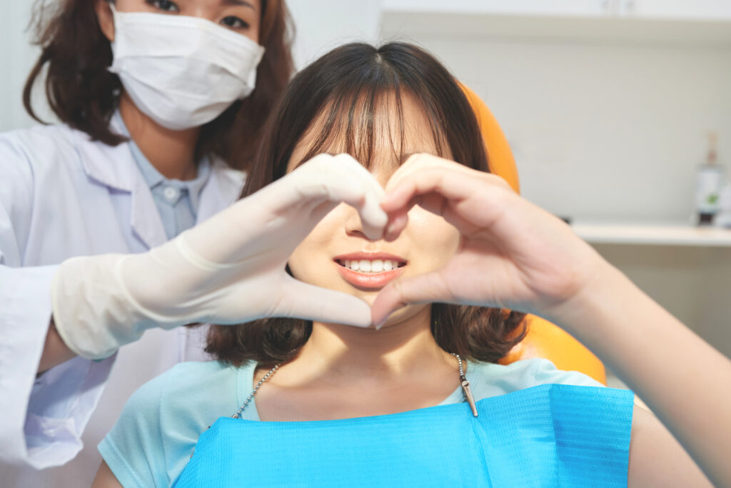 young woman with doctor making heart symbol 2023 11 27 05 36 15 utc